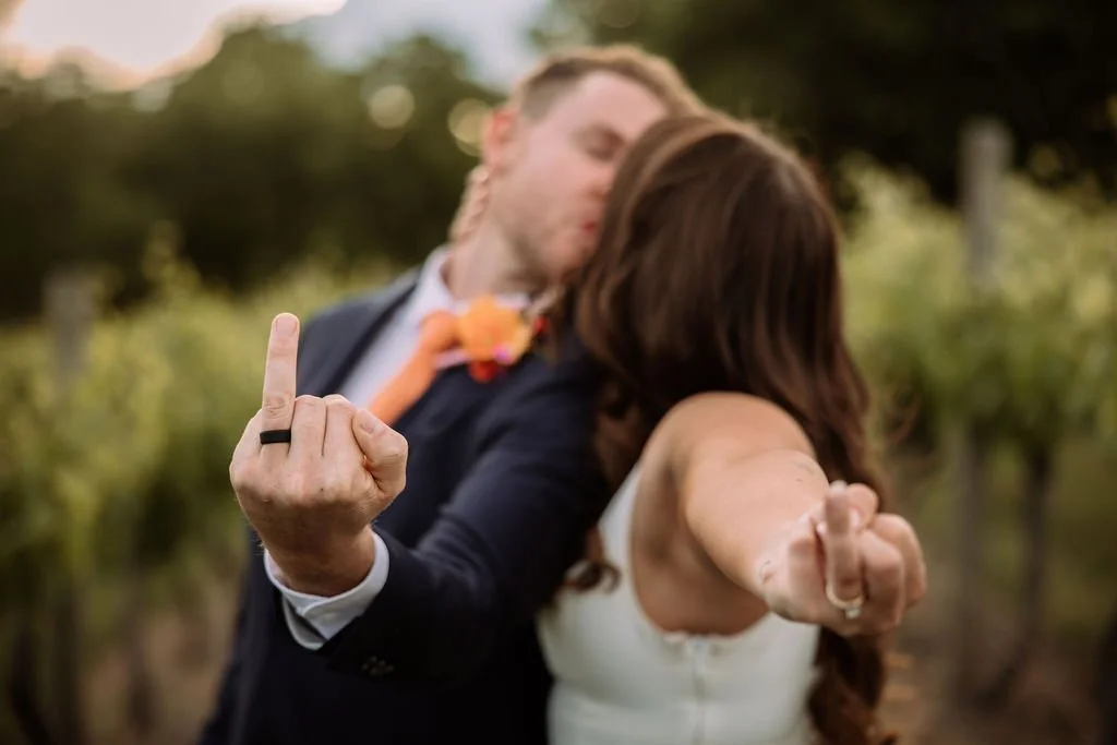 Bec and Luke posing playfully together during their vineyard wedding portraits