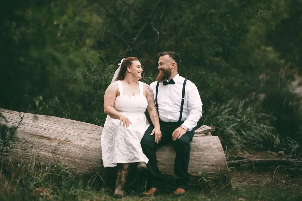 Bronti and Juan-Ruan sitting together during their outdoor wedding portraits