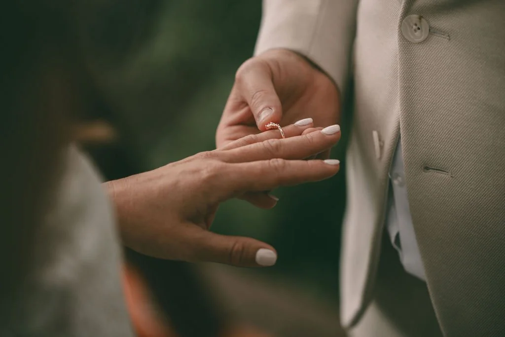 Close-up of Allysha and Corey holding hands with wedding rings visible