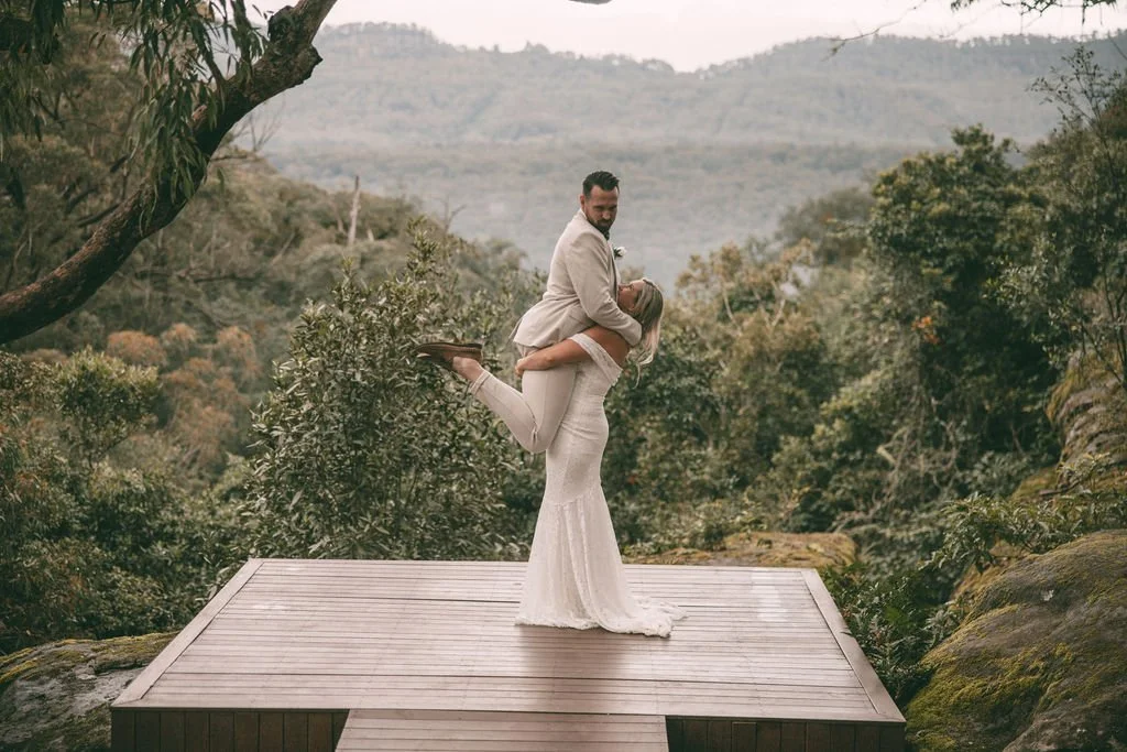 Allysha and Corey sharing a playful wedding portrait on a scenic lookout platform