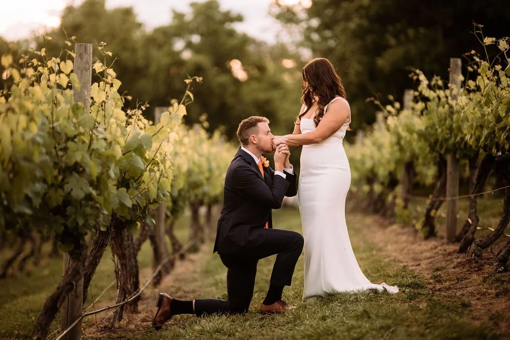 Luke kneeling and kissing Bec’s hand during their vineyard wedding portraits