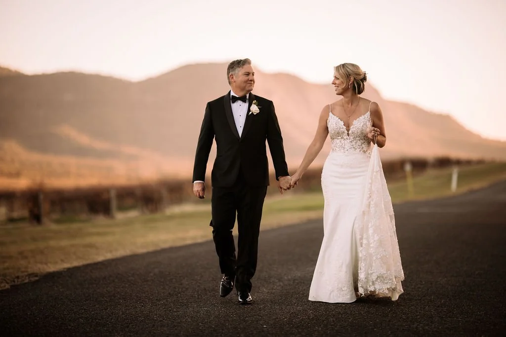 Brendon and Kate walking hand in hand during golden hour wedding portraits