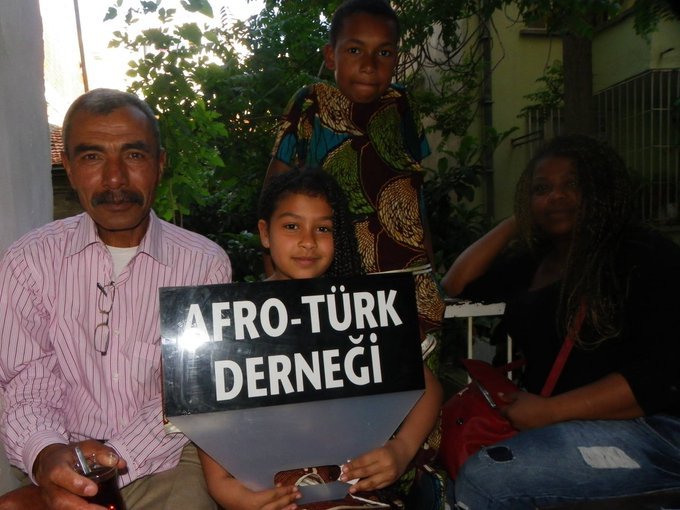 Mustafa Olpak with other Afro Turks with a sign for the Afro Turkish Association.