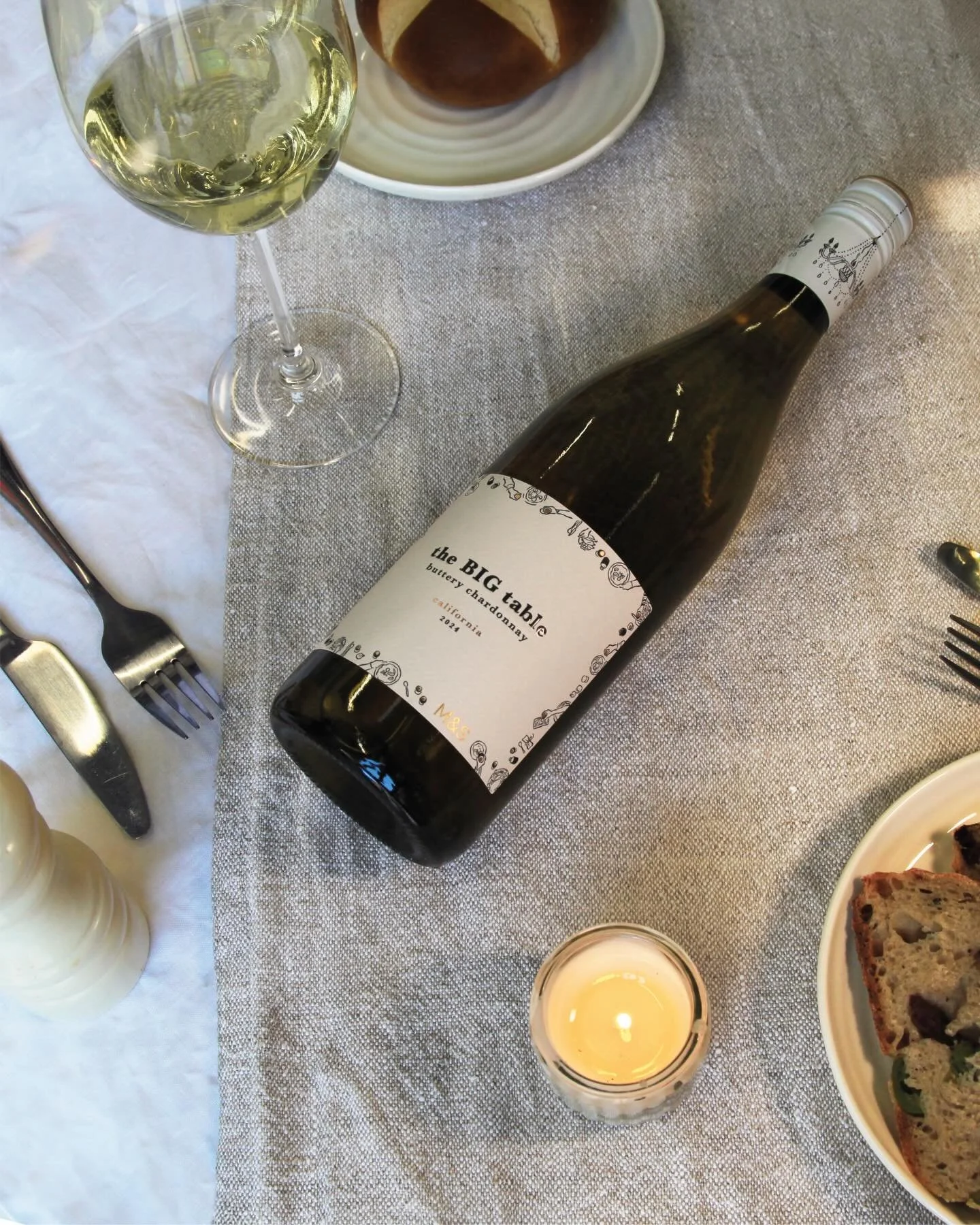 Designed for M&amp;S, The Big Table uses an illustrated frame that features the simple rituals of eating and drinking together. With plates and glasses grouped around the edges of the label canvas creating a charming visual narrative, the restrained 