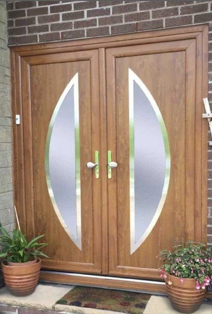 Double UPVC Composite front doors with frosted glass panels and metal handles, flanked by potted plants on a doorstep.