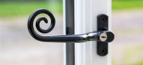 Close-up of a black metal door handle with a spiral design.