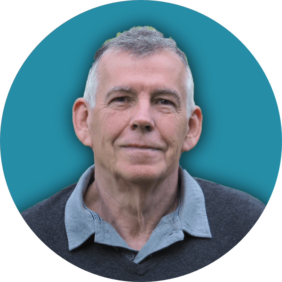 John King with gray hair and a neutral expression, wearing a collared shirt, against a teal background.
