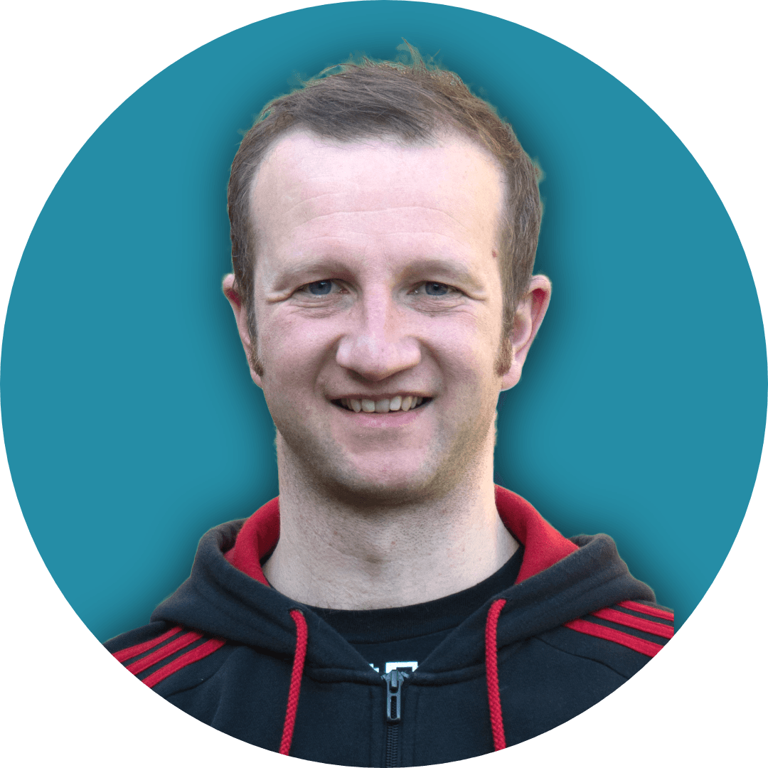 Sam Huggill smiling, wearing a black hoodie with red accents, set against a teal background.