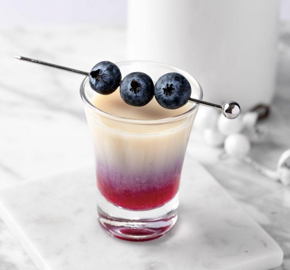How about a blueberry muffin shot? Just here to help! 

1 oz RumChata
1 oz vodka 
1 oz blueberry syrup 

Add the RumChata and vodka to a cocktail shaker filled with ice. Shake well for 20 seconds and strain into a shot glass.
Gently pour the blueberr
