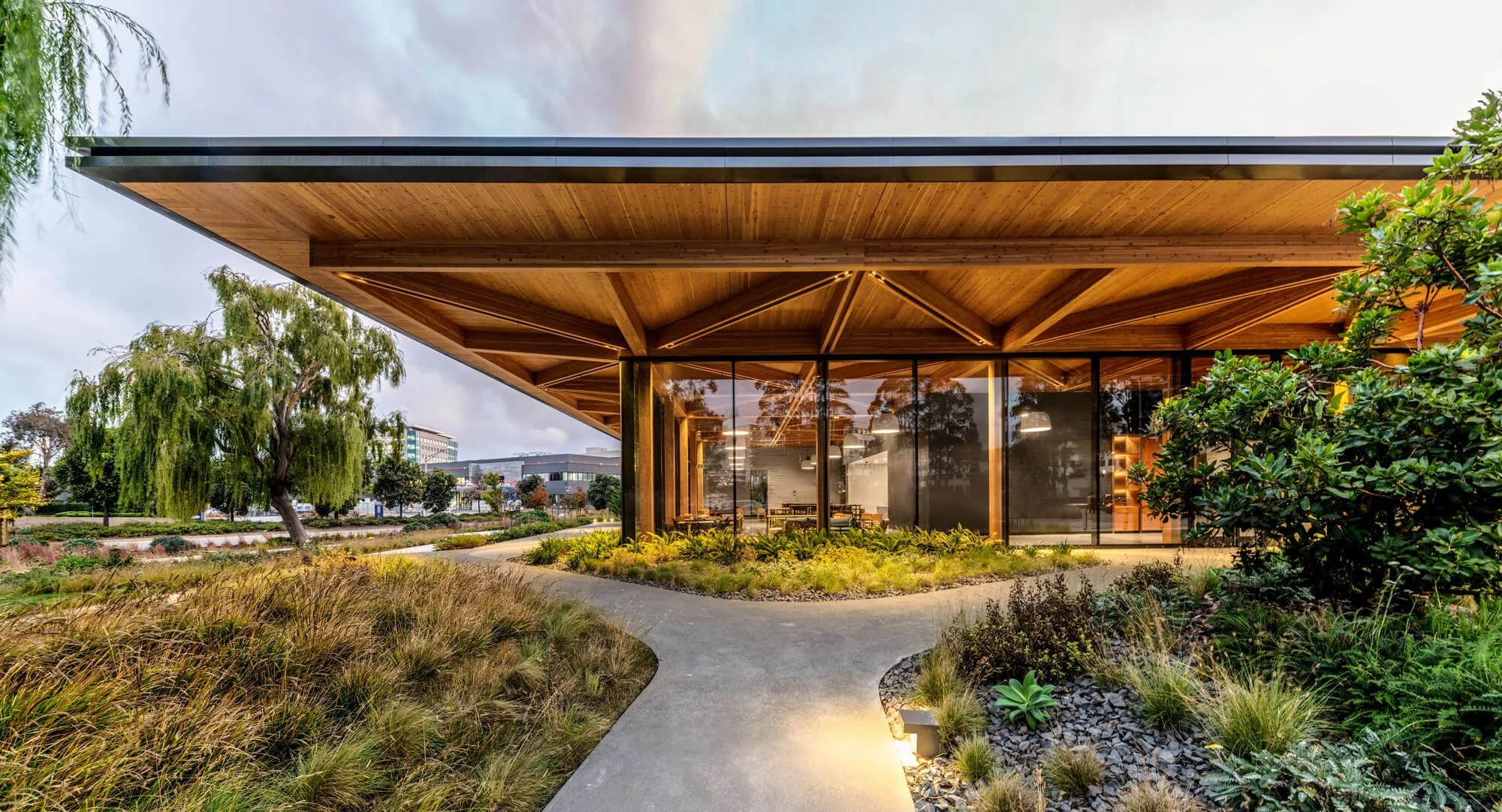 Outside view of Timber and Tide showing the beautiful large windows and wood timbers with gorgeous low water landscaping