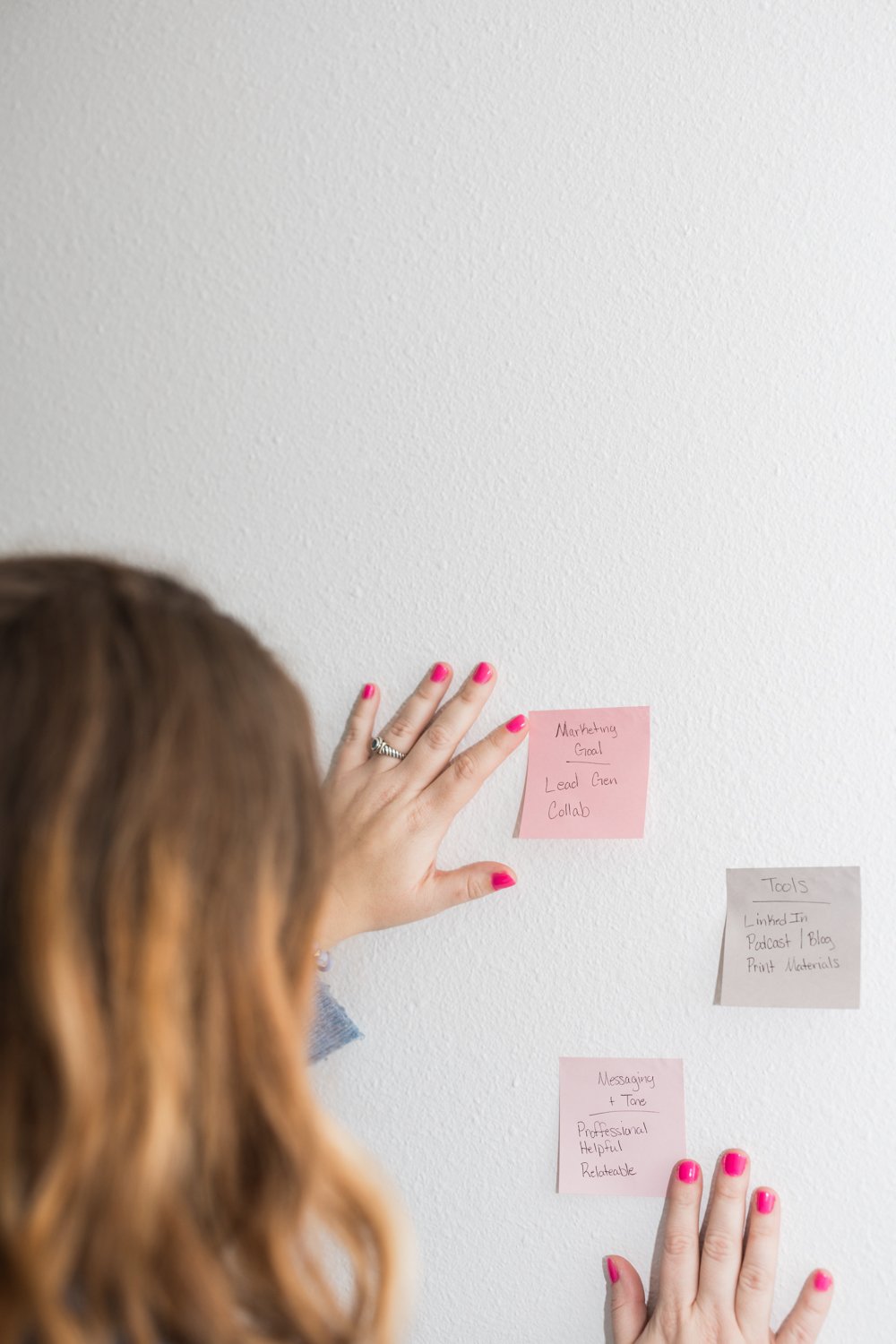 woman putting post it notes on wall