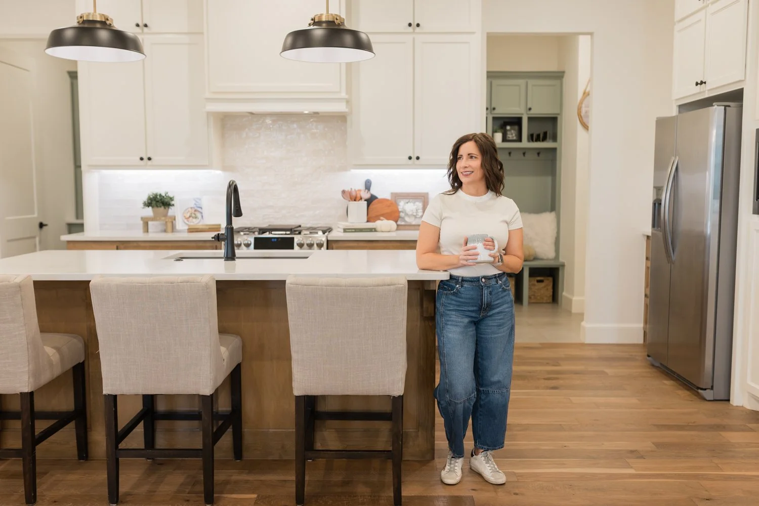 Cari of Rose Rock Mortgage drinking morning coffee during brand session in Norman model home