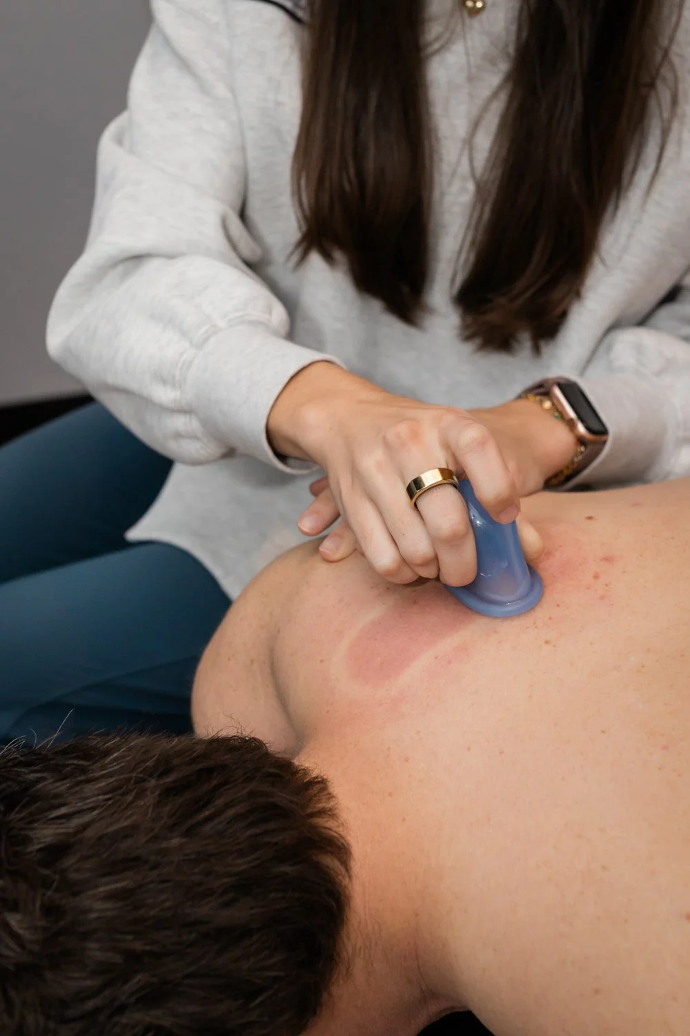 Brand session image of physical therapist working with client on rehab table