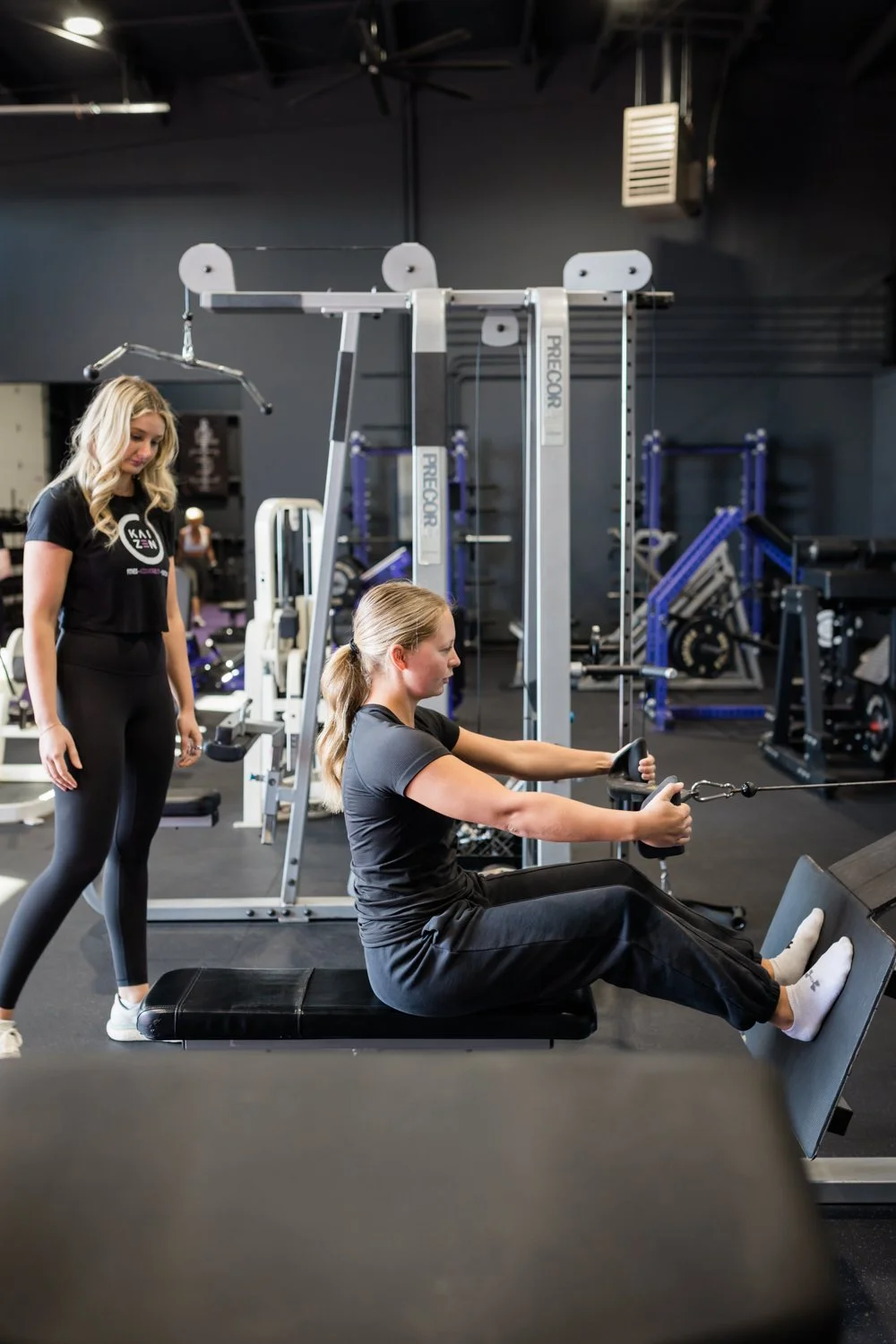 personal trainer coaching client with proper form guidance