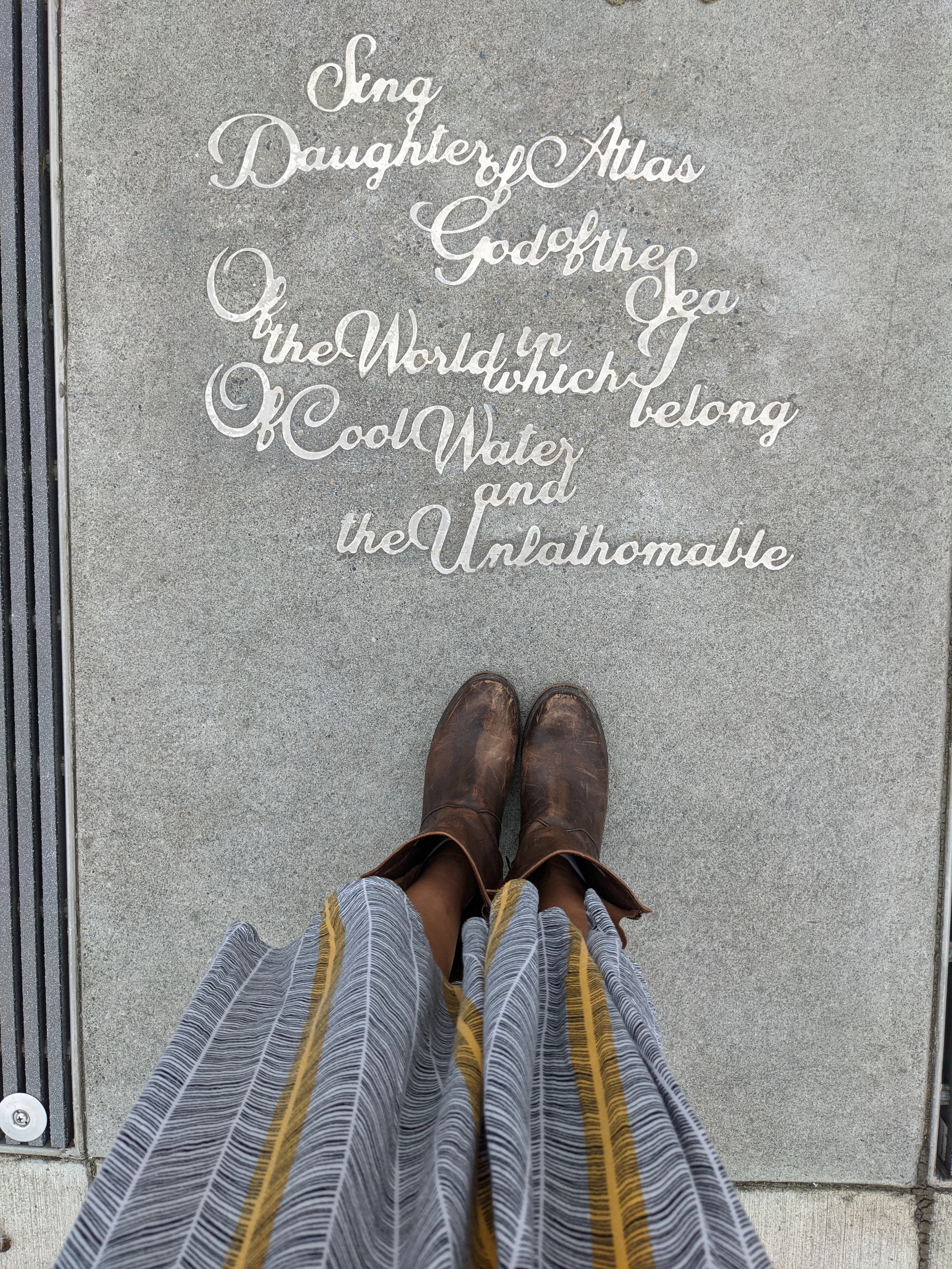 Laura's shoes next to a poem written on the pavement