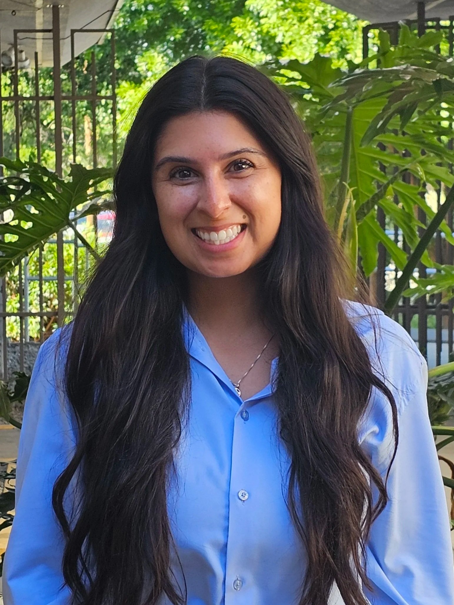 Nurse Practitioner Clarissa Avalos smiling in front of greenery