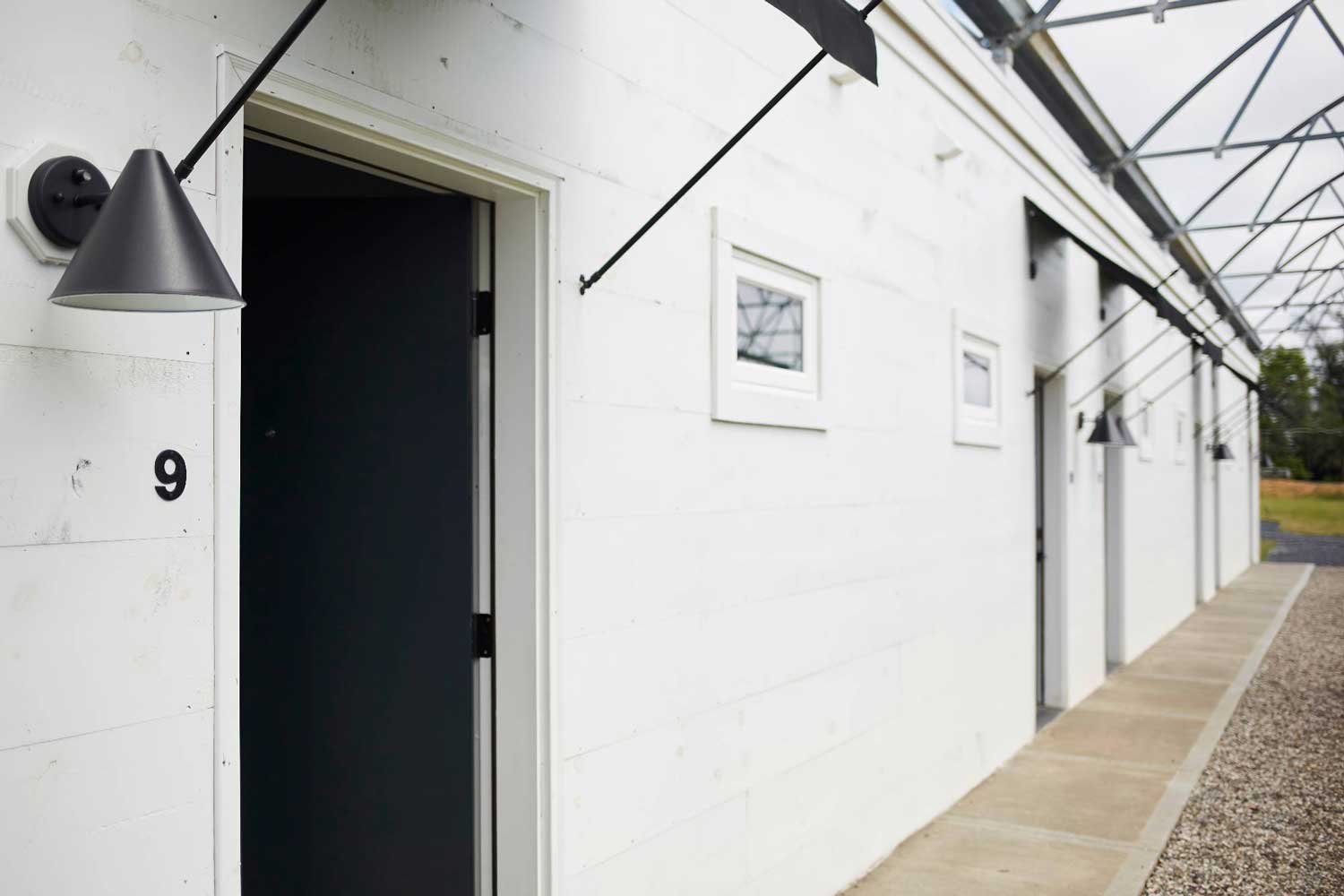  A view of the doors to the rooms at the Greenhouses hotel, with a close up view of Door #9. Each door has an awning over the door as well as a light to the left. Photo by Tad Mask. 