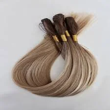 Sample hair extensions in various shades of blonde, bundled and tied with gold bands.