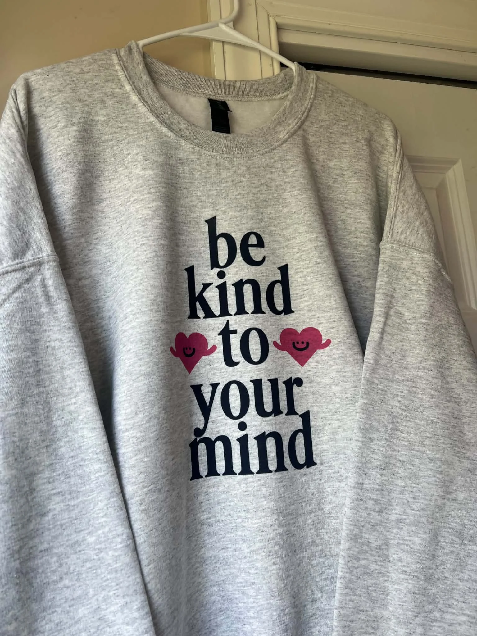 gray sweatshirt with be kind to your mind printed on it