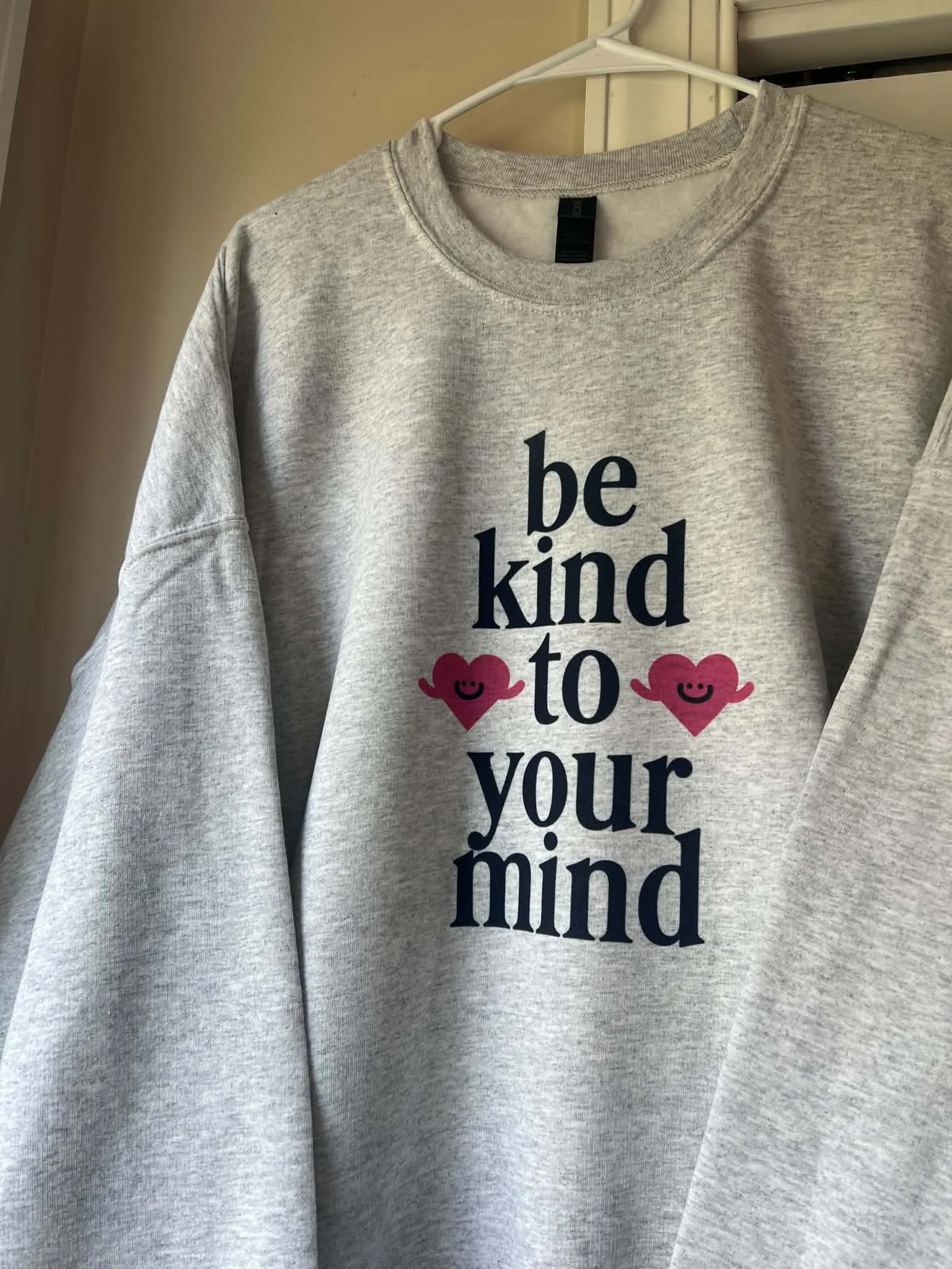 gray sweatshirt with be kind to your mind printed on it