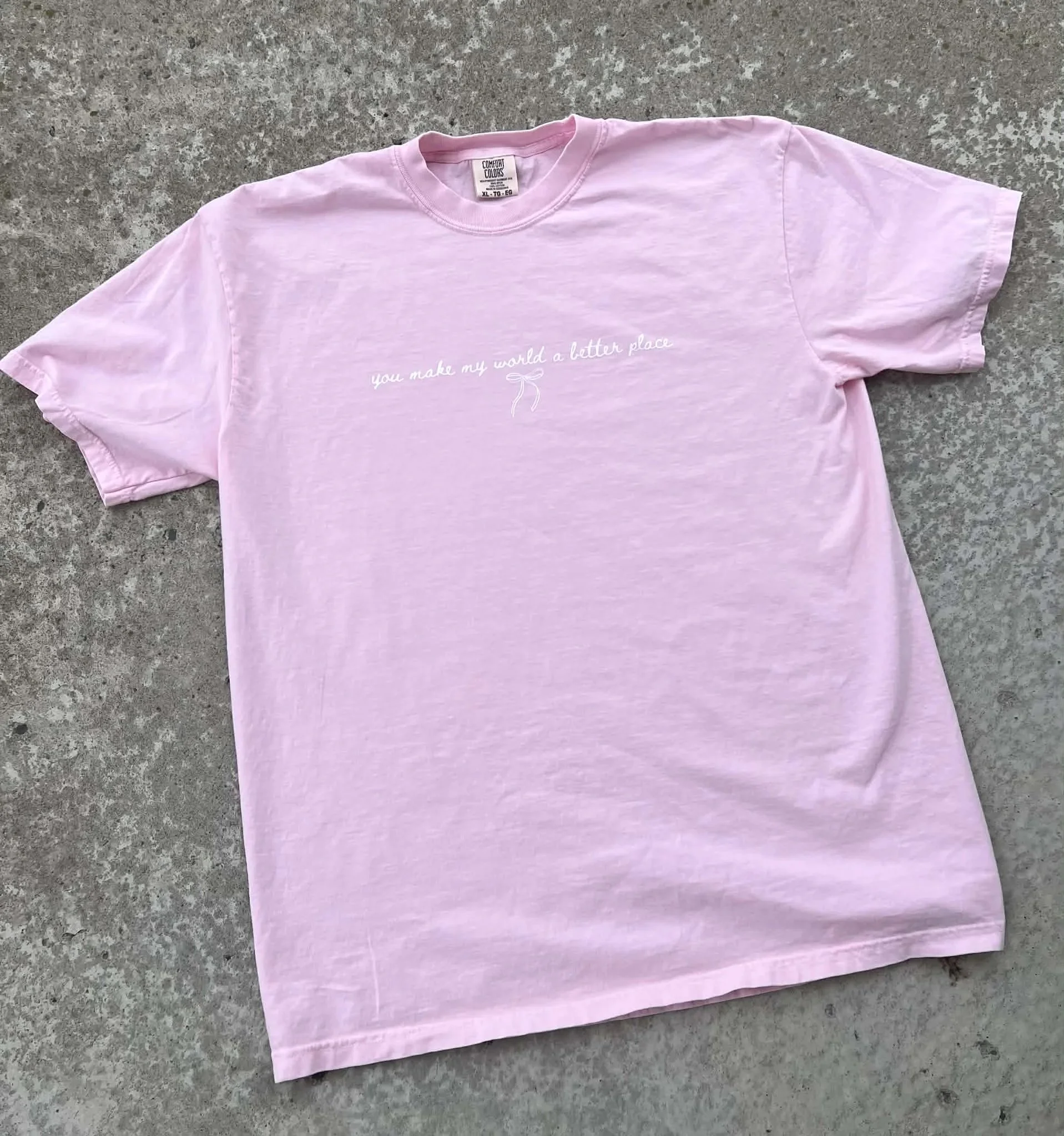 Pink tee with white text reading 'you make my world a better place"