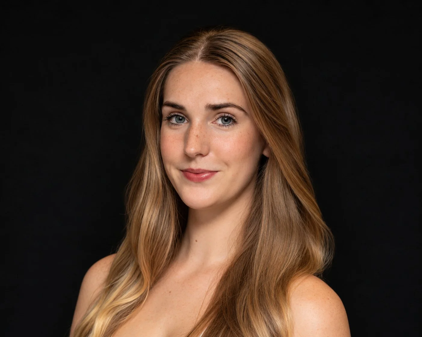 Portrait of a young woman with long blonde hair, blue eyes, and fair skin, looking at the camera against a dark background.