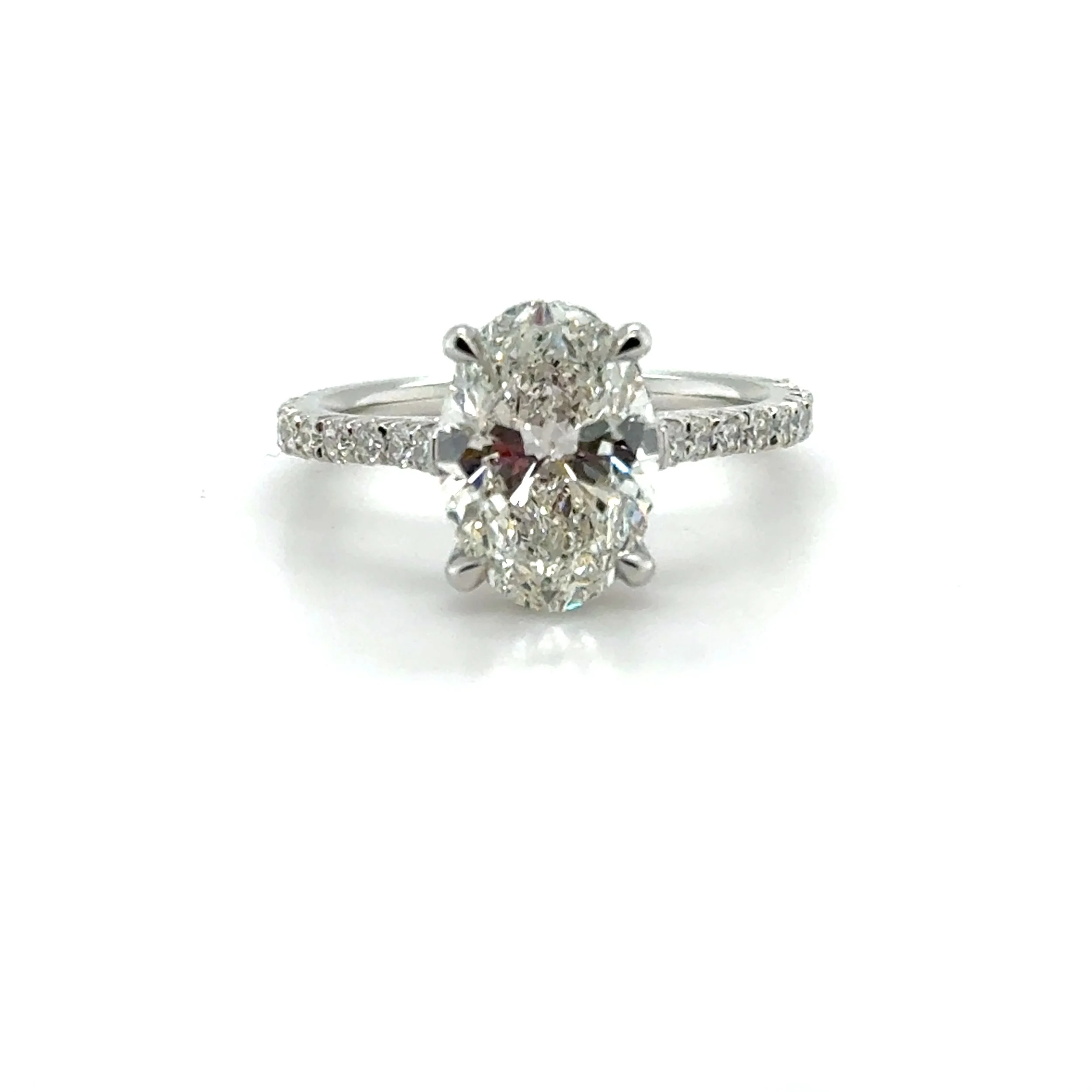 Close-up of a diamond engagement ring with a large central diamond and smaller diamonds on the band, set against a plain white background.
