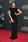 Shelly Henning, actress, in a black evening gown, standing on a red carpet at an awards event.