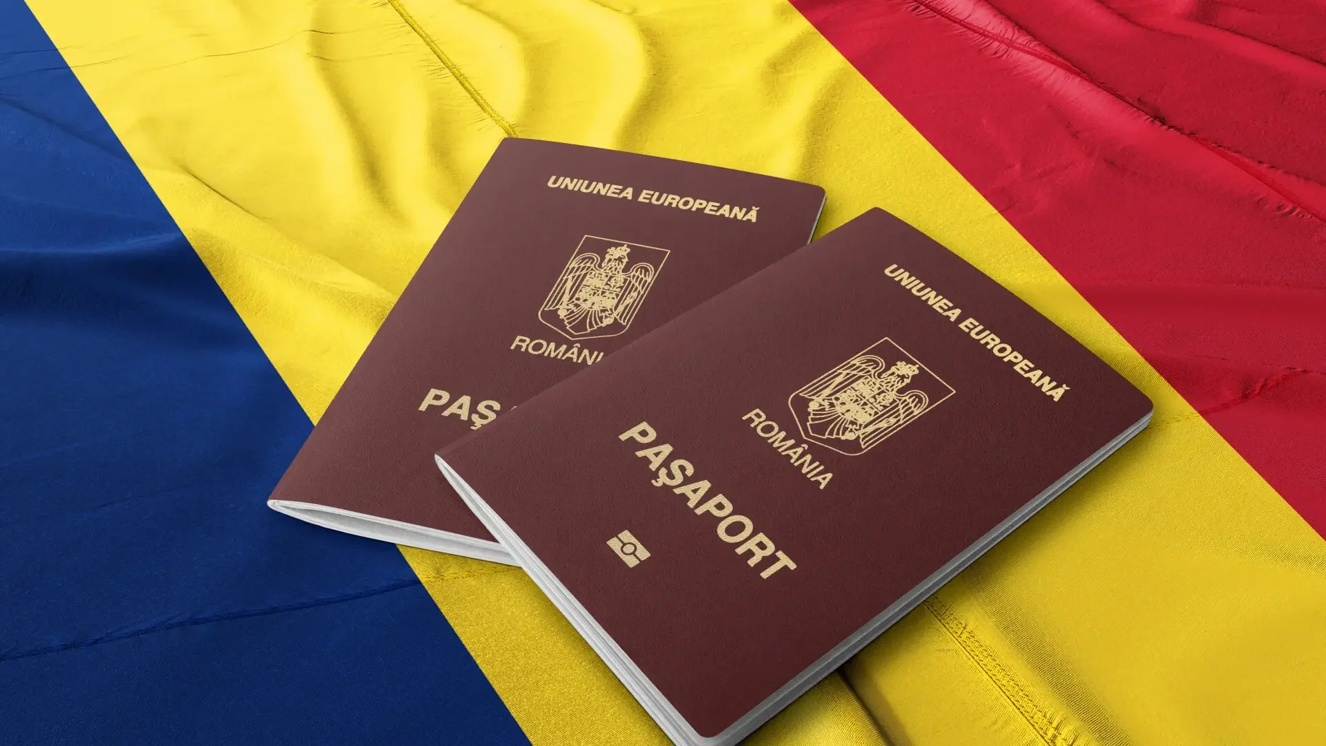 Two Romanian passports on a clutch with the national colors of Romania, red, yellow, and blue.