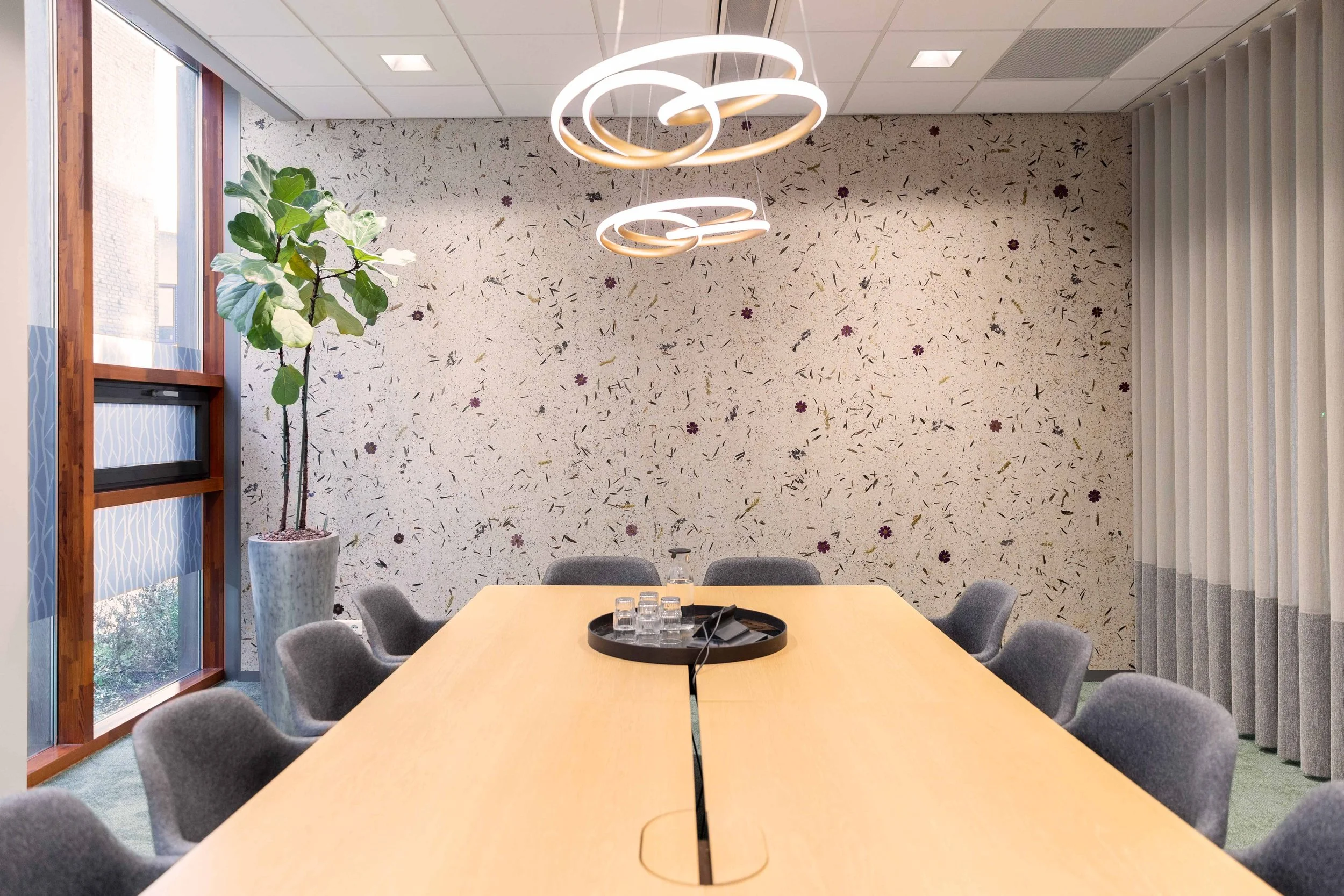 Trouwkamer met behang van echte bloemen , grote houten tafel en gordijnen.