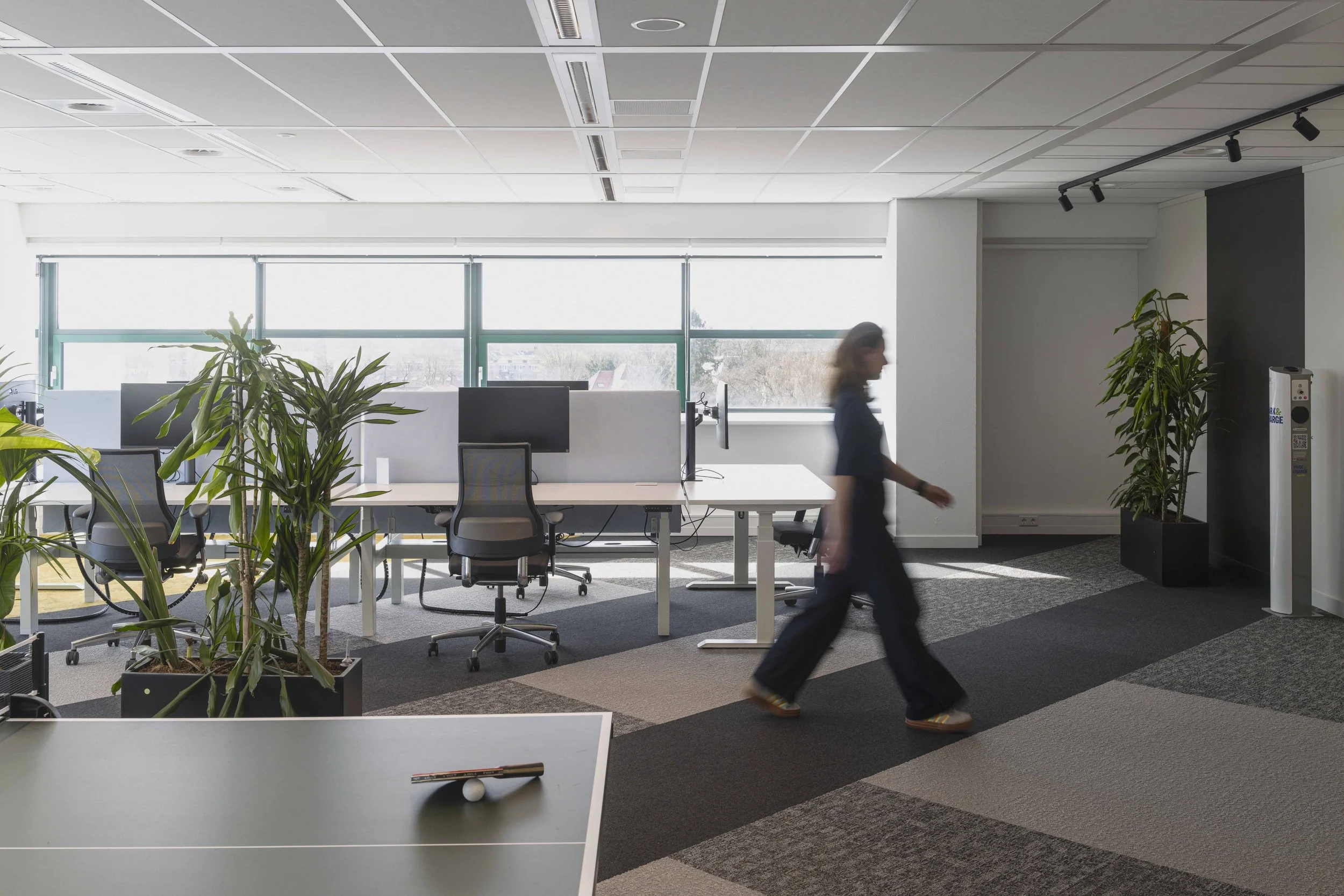 Werkplekken met hergebruikt meubilair binnen een circulair kantoorinterieur voor Qwello