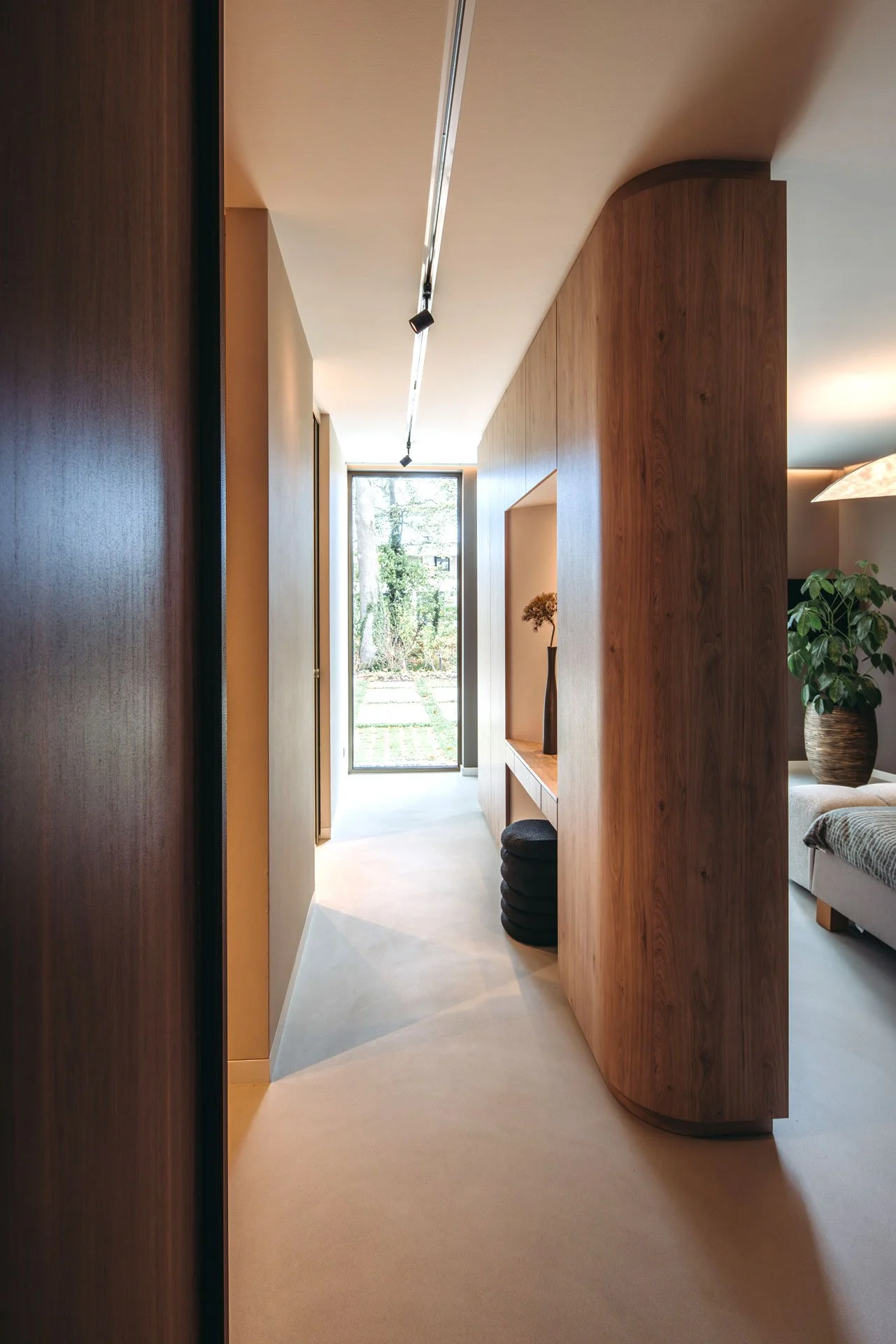 Master bedroom met organisch gevormde houten kast die functioneert als divider. 