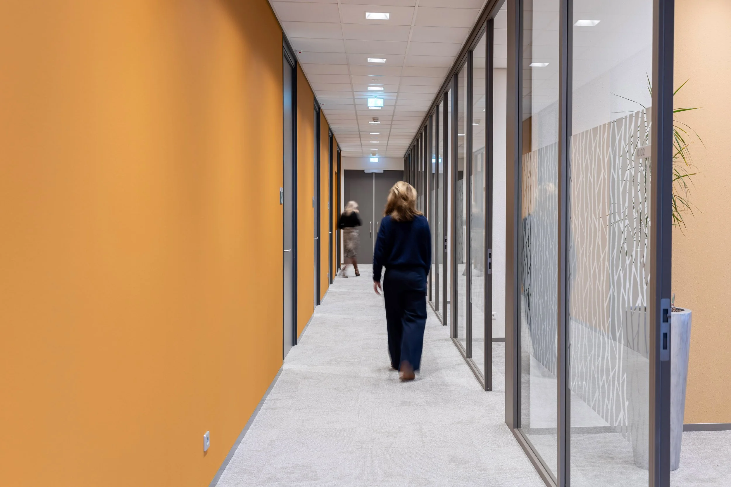 Circulair interieur met hergebruikte materialen zoals glazen wanden en refurbished meubilair in De Post kantoor.