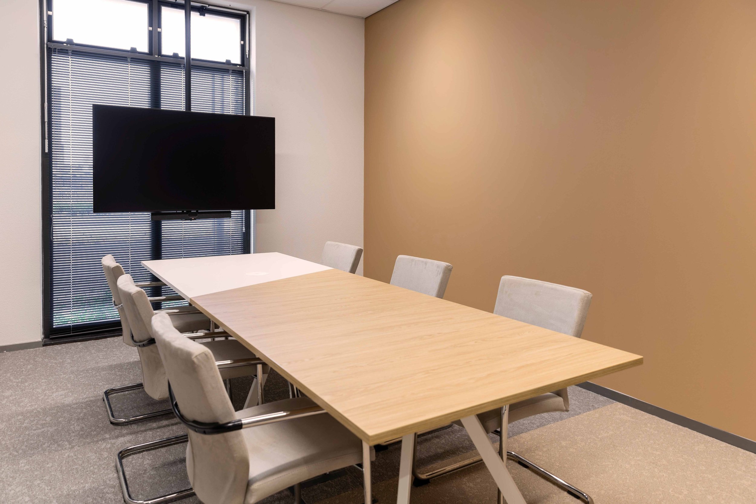 Subtiel kleurgebruik in vloer en wand dat samenhang en variatie creëert in het kantoor van De Post.