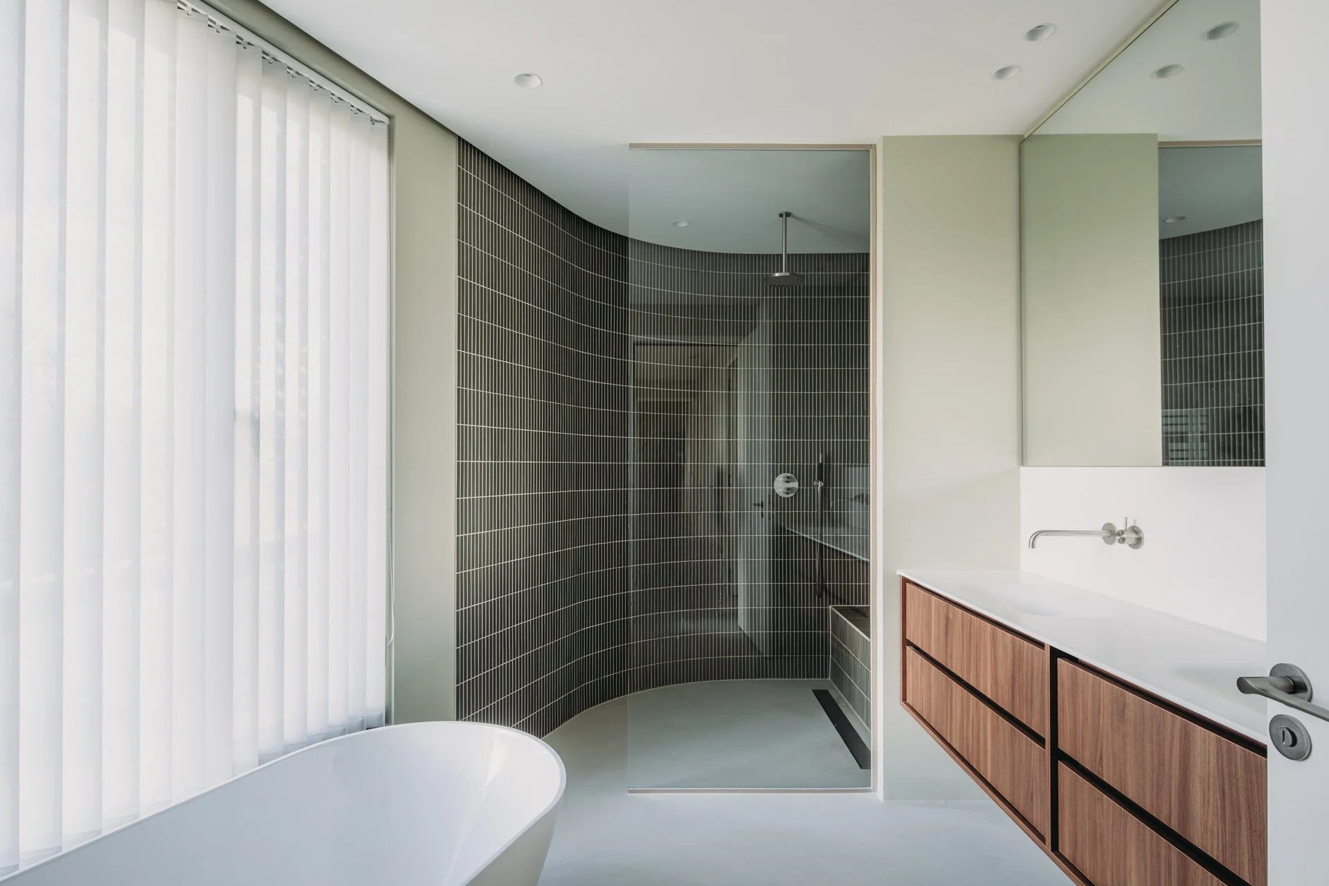 Badkamer met frisse groentinten en gebogen met donkergroen mozaïek. Maatwerk houten wastafelmeubel.