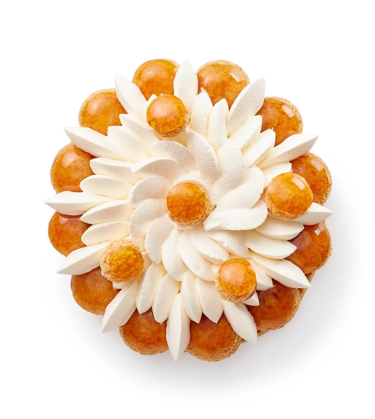 Gâteau décoré de crème blanche et de petits choux dorés, disposés en forme de fleur.
