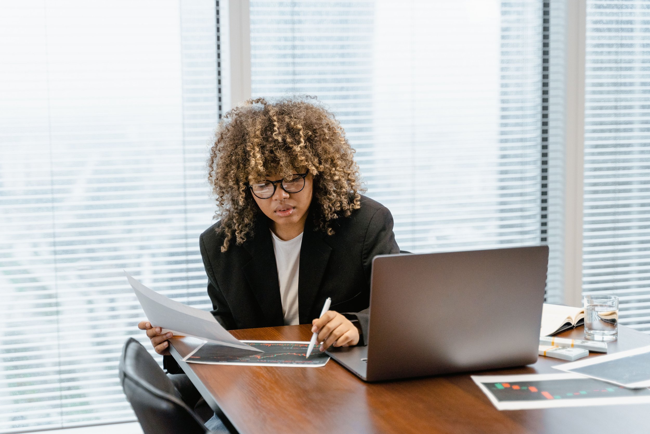 A person working at a desk with a laptop and printed documents