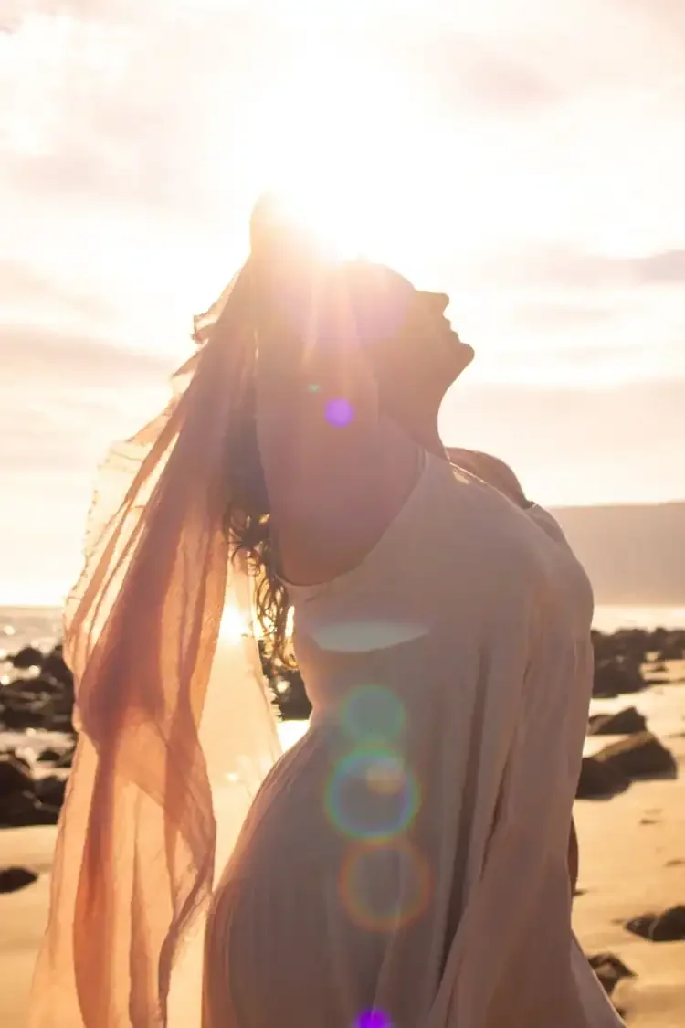 woman looking happily at the sky on the beach after a therapy session