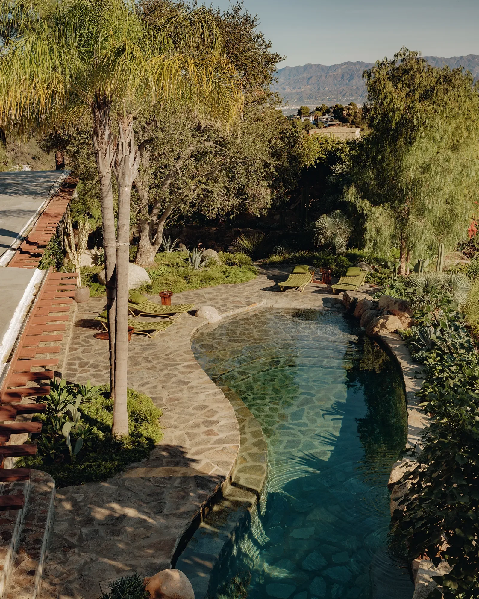 Michel Architects Los Angeles historic home restoration — aerial view of De Jonghe Residence in Laurel Canyon, Los Angeles, showing organic-form pool, stone paving, and native California landscape