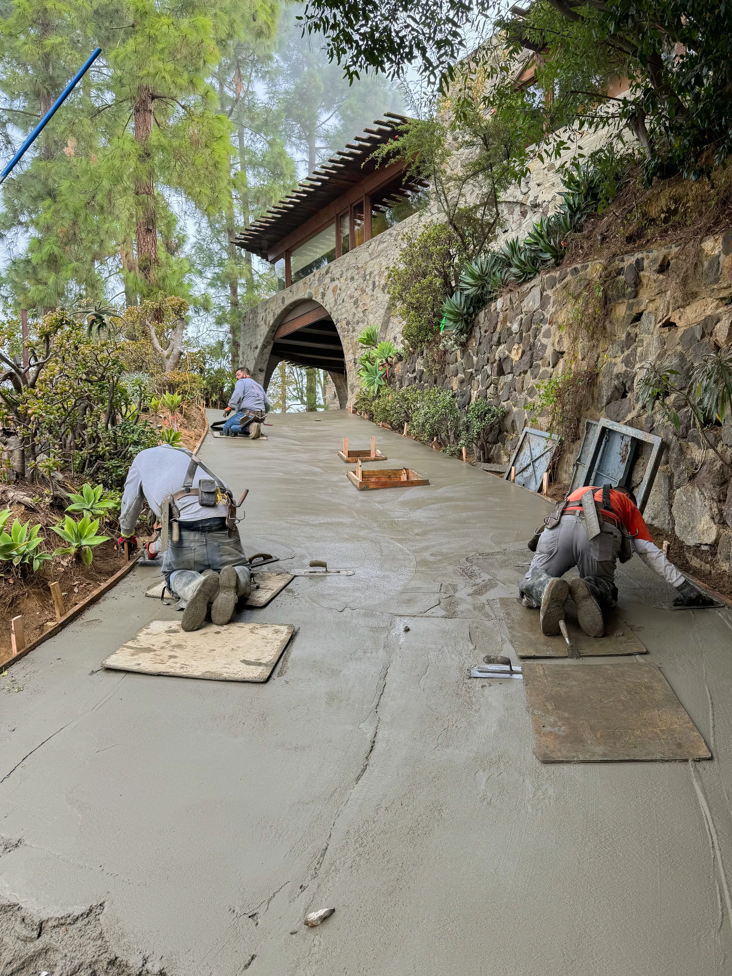 Workers prepare the driveway surface for new flagstone pavers at the De Jonghe Residence in Laurel Canyon, Los Angeles, restored by Michel Architects