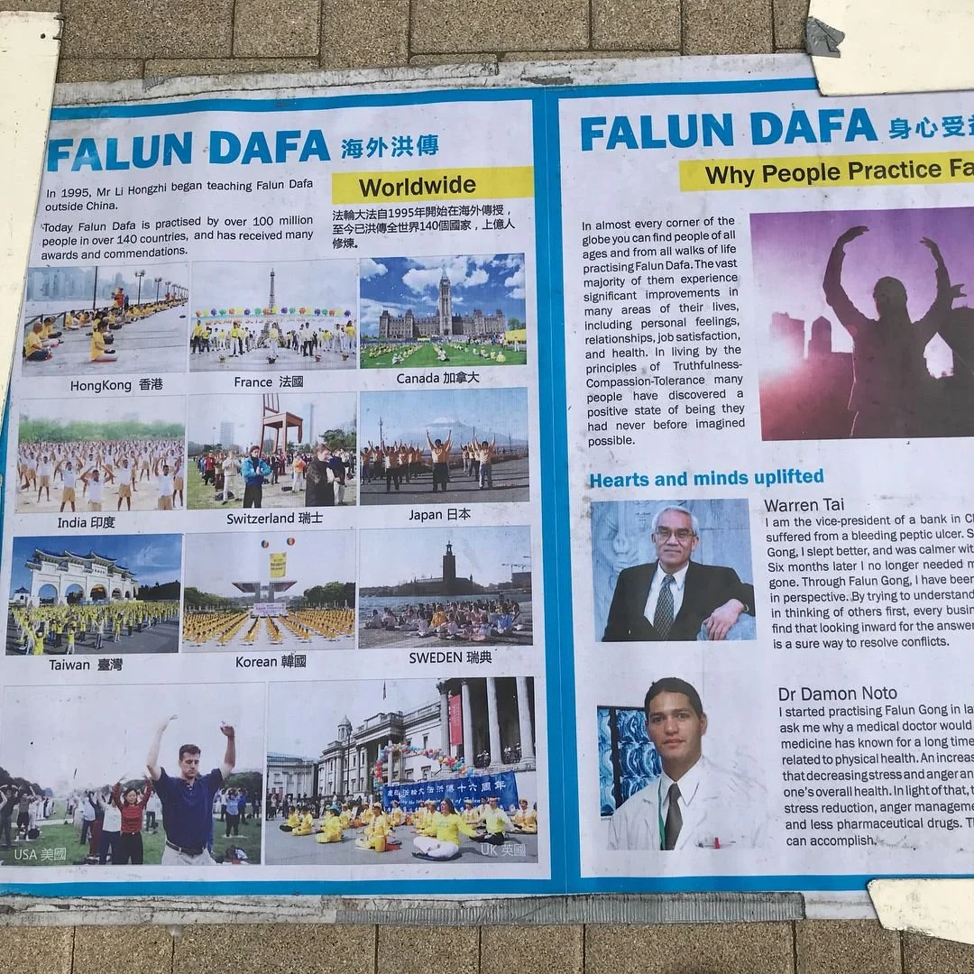 An informational poster about Falun Dafa with photos from around the world including Hong Kong, France, Canada, India, Switzerland, Japan, Taiwan, Korea, Sweden, the USA, and the UK, and text explaining its practice and benefits.