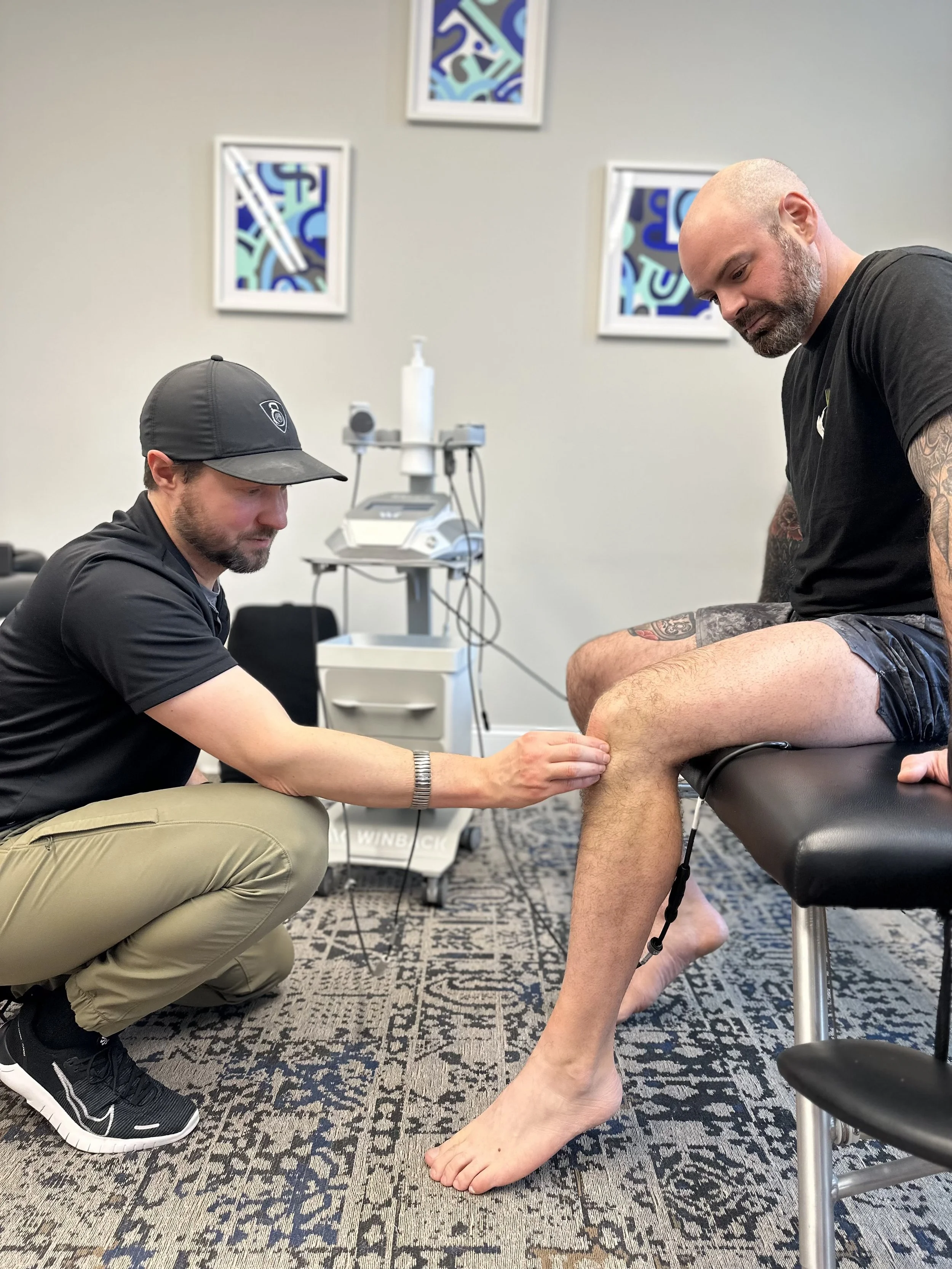Chiropractor applying Winback TECAR therapy using a RET bracelet to support tissue recovery, reduce pain, and improve mobility at Ecotone Performance Health and Fitness in Saratoga Springs, NY.