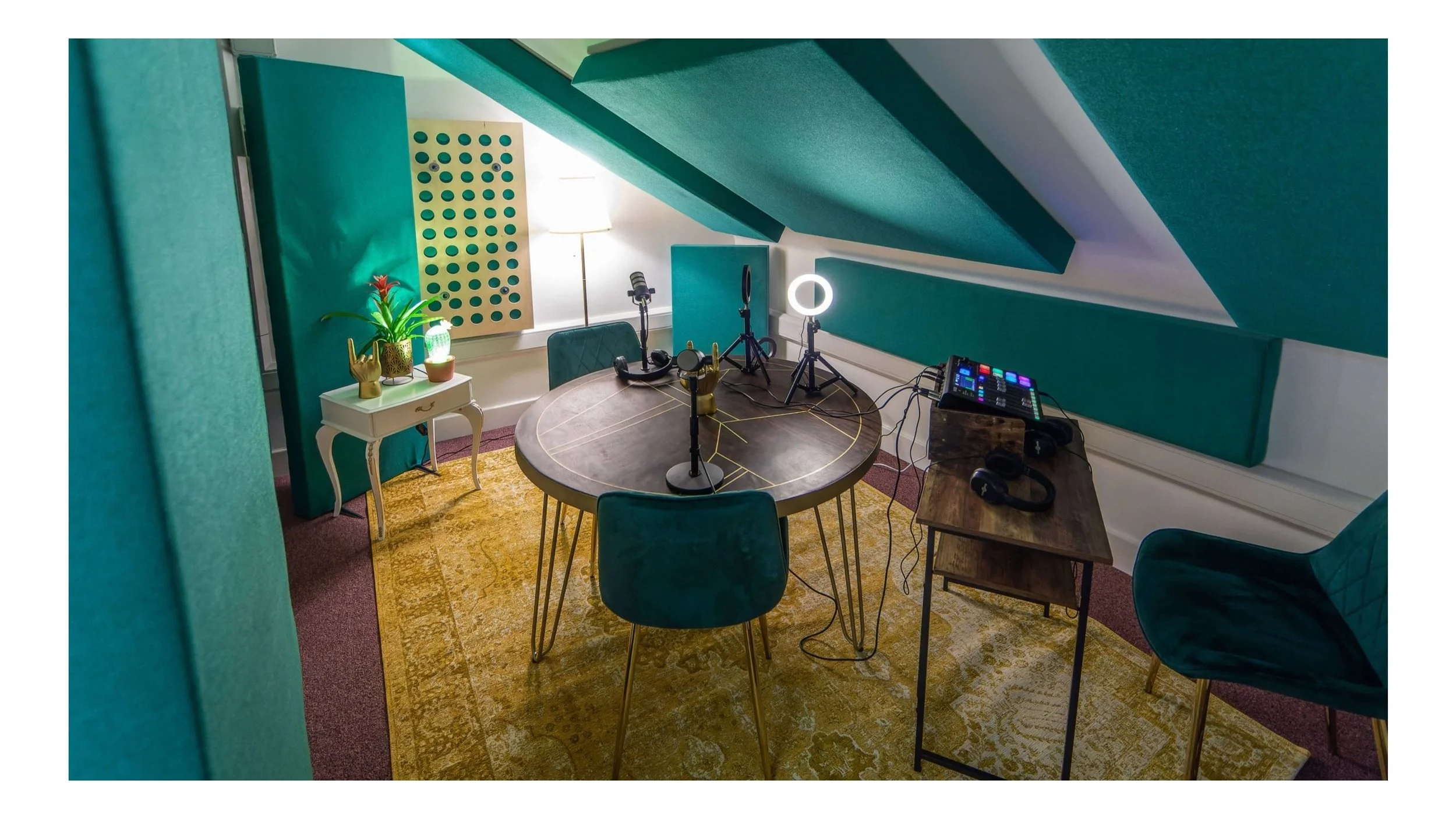 Flamingo Heights The Nest podcast studio with microphones, chairs and teal acoustic walls