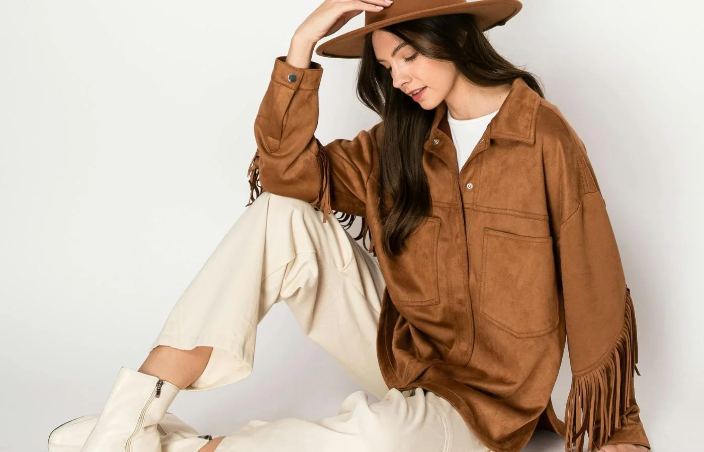 wardrobe organization tips Women sitting down and holding a brown hat