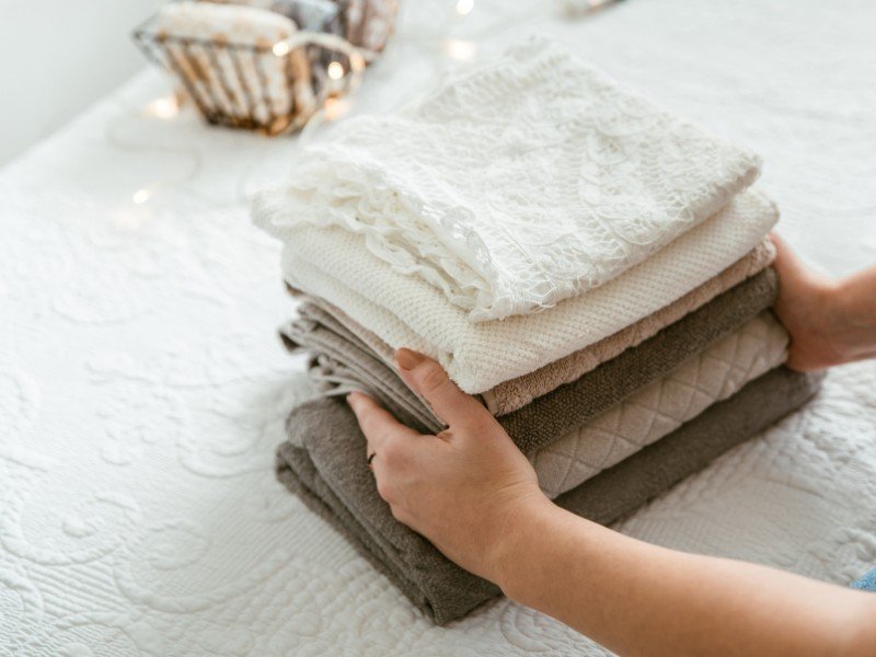 Folded linens arranged on a bed.