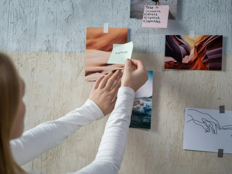 Pinning photos and notes on board.