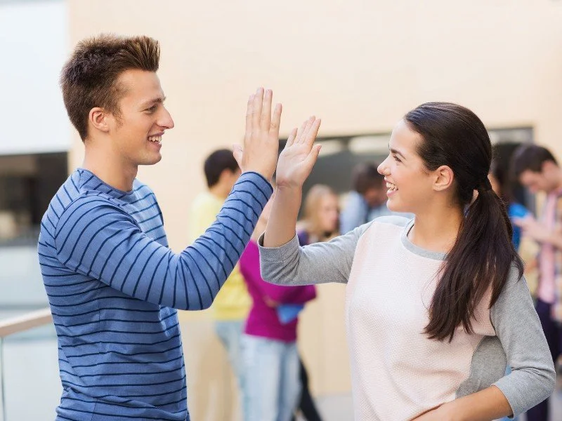 High-five celebrating teamwork outdoors.