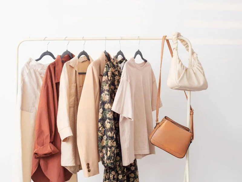 Clothing and handbags displayed on racks.