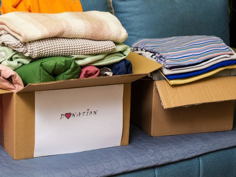 Donation boxes filled with neatly folded clothes. (Copy) (Copy)