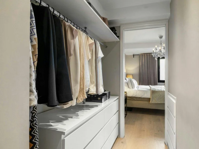 Organized wardrobe with hanging clothes.